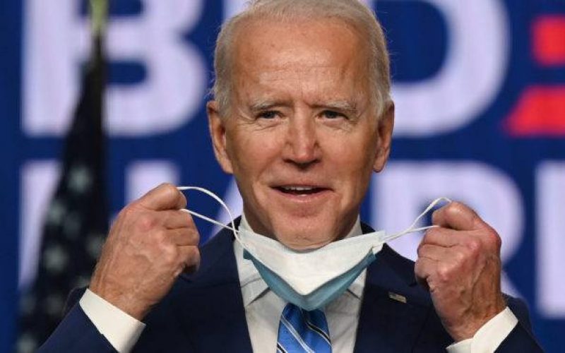 Democratic Presidential candidate Joe Biden removes his mask before speaking at the Chase Center in Wilmington, Delaware on November 4, 2020. - President Donald Trump and Democratic challenger Joe Biden are squaring off for what could be a legal battle for the White House, running neck-and-neck in the electoral vote count, and several battleground states still in play on November 4. (Photo by JIM WATSON / AFP)