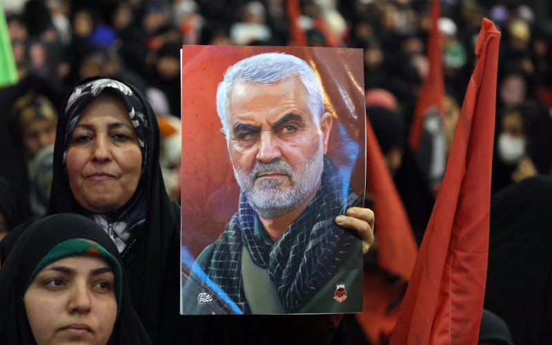 An Iranian woman holds a portrait of slain top Iranian commander Qasem Soleimani during the commemoration ceremony marking the anniversary of his killing in the Iranian capital Tehran on January 3, 2024. Twin bomb blasts killed at least 103 people in Iran, ripping through a crowd commemorating Revolutionary Guards general Qasem Soleimani four years after his death in a US strike, state media reported. (Photo by ATTA KENARE / AFP)