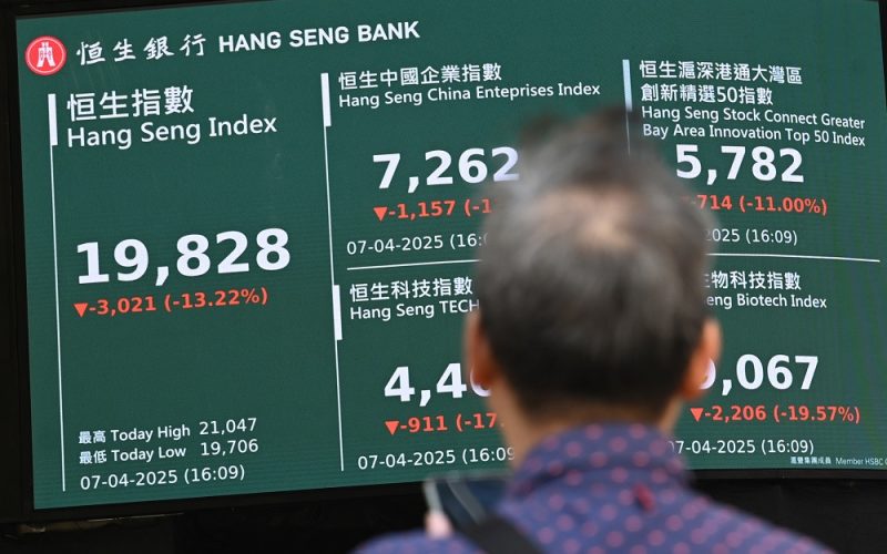 A man looks at an electronic sign board showing the closing price of the Heng Seng Index in Hong Kong on April 7, 2025. Shares in Hong Kong plummeted more than 13 percent April 7 on their worst day in almost three decades as China's retaliation against Donald Trump's tariffs ramped up a trade war and fuelled recession fears. (Photo by Peter PARKS / AFP)